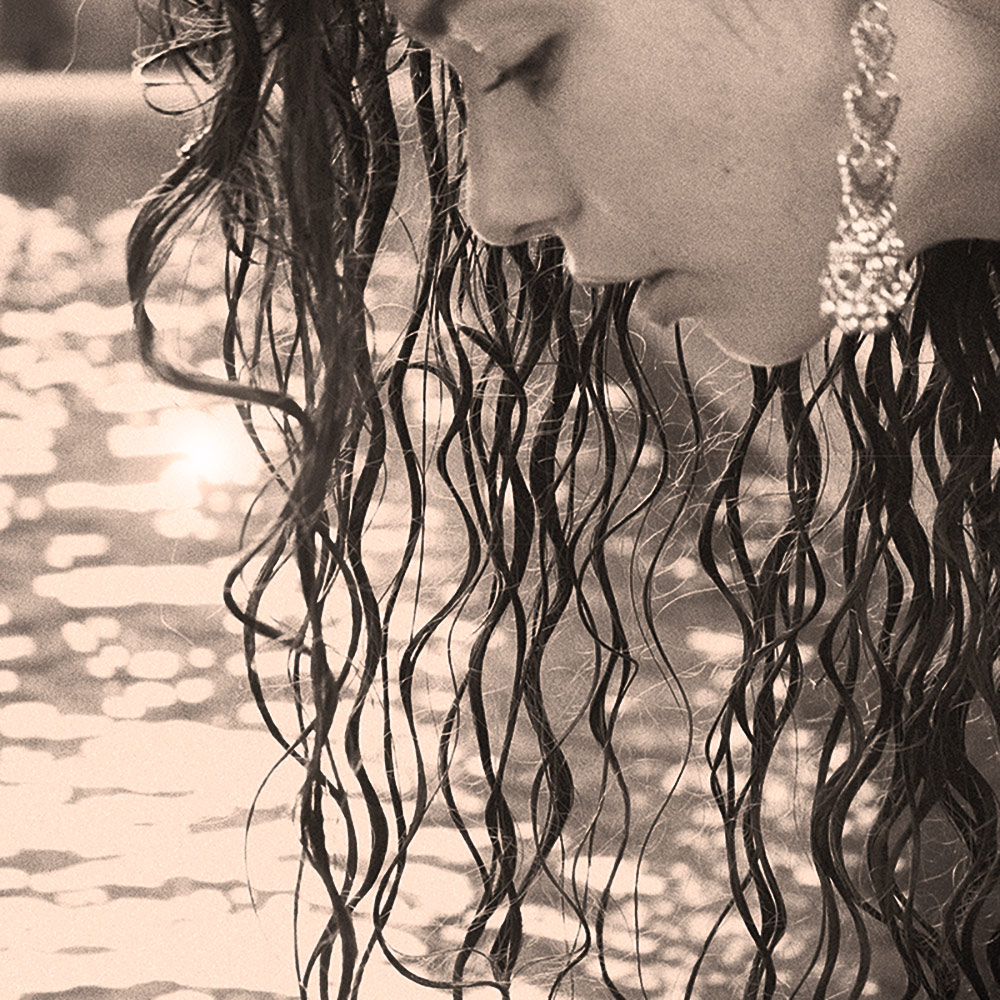 AZURE, artist, leaning over a body of water at sunset.